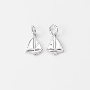 May include: Two silver sailboat charms with a small clear rhinestone on each sail.