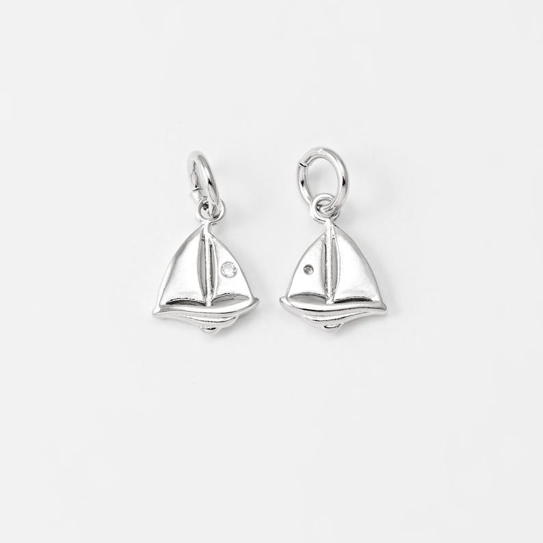 May include: Two silver sailboat charms with a small clear rhinestone on each sail.