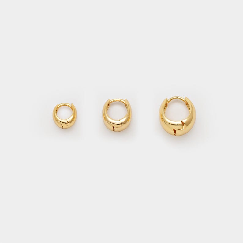 May include: Three gold-coloured hoop earrings of varying sizes are displayed against a white background. The earrings have a smooth, rounded design with a hinged closure. The smallest earring is approximately 1.3 cm in diameter, the medium is 1.9 cm, and the largest is 2.5 cm.