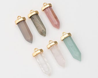 May include: Six gold-plated crystal point pendants with different colored stones. The stones are clear, pink, gray, green, white, and a dark gray with gold flecks.