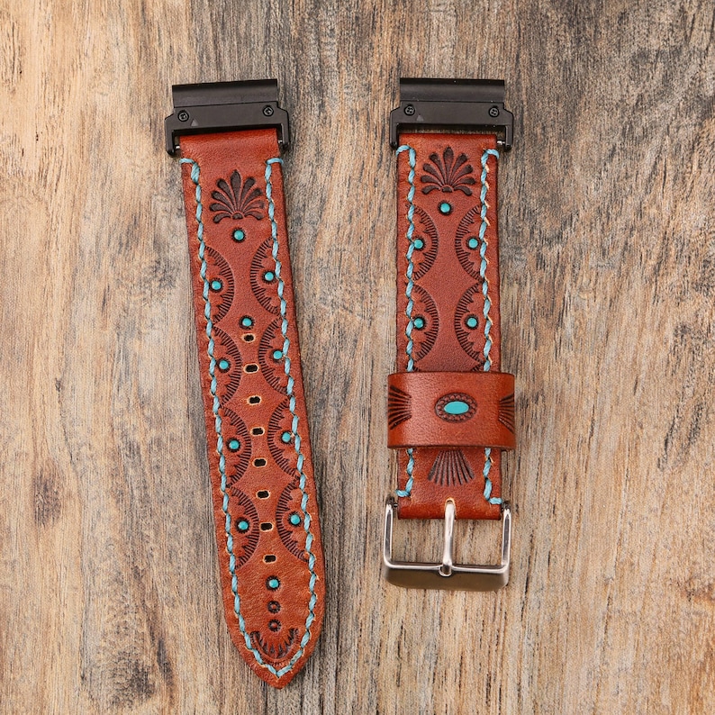 May include: Two brown leather watch bands with black hardware and silver buckles. The bands feature turquoise accents and decorative stitching. The bands have a Southwestern design with floral and geometric patterns.