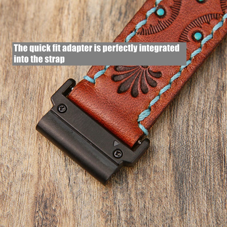 May include: Close-up of a brown leather watch strap with a black quick fit adapter. The strap features turquoise stitching and a floral embossed design. The text "The quick fit adapter is perfectly integrated into the strap" is visible.