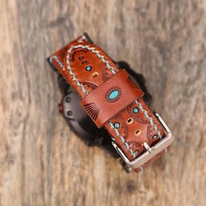 May include: Brown leather watch band with turquoise accents and decorative stitching. The band features a silver buckle and a detailed pattern. The watch band is designed with a Southwestern style.