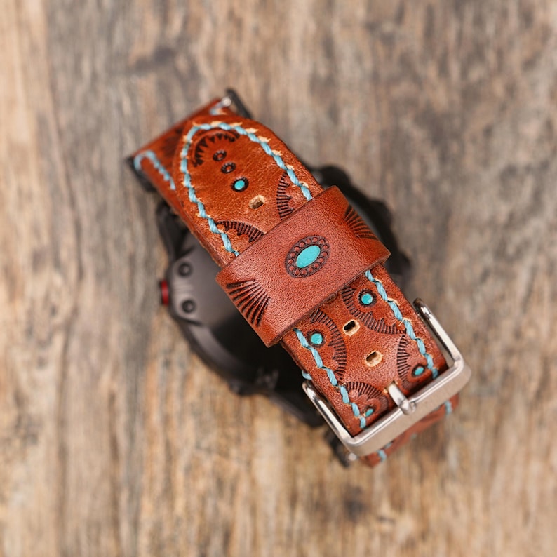 May include: Brown leather watch band with turquoise accents and decorative stitching. The band features a silver buckle and a detailed pattern. The watch band is designed with a Southwestern style.