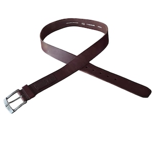 May include: A dark brown leather belt with a silver-colored buckle. The belt has a rectangular leather loop near the buckle and several holes for adjustment. The belt is displayed against a white background.
