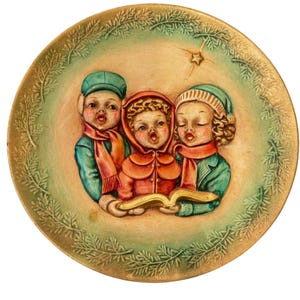 May include: A decorative ceramic plate featuring a Christmas carol scene. Three children in winter attire sing from a golden book, surrounded by a green and gold border with a star. The children wear hats and scarves.