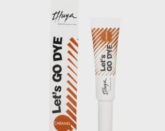 May include: A white tube and box of "Let's Go Dye" caramel-colored dye. The tube has a white cap and the box has the brand name "Thuya" and the words "Let's Go Dye" in large, bold letters. The word "Caramel" is also visible.