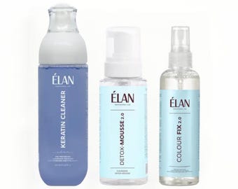 May include: Three bottles of ÉLAN Professional Line hair products. The bottles are labeled Keratin Cleaner, Detox Mousse 2.0, and Colour Fix 2.0. The bottles are white and blue, with the brand name in a white font. The Keratin Cleaner bottle is the largest.