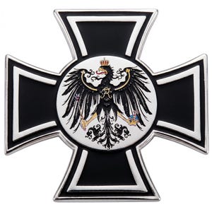 May include: A metal cross-shaped emblem featuring a black cross with silver borders. In the center, a circular white medallion displays a black eagle with gold accents, wearing a crown and holding a scepter and an orb, with a gold letter R on its chest.