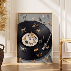 May include: A framed art print featuring a black vinyl record with various dog breeds illustrated on it. The dogs are arranged around the record and on the surrounding gray background. The frame is gold-colored.