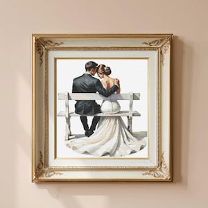 以下が含まれることがあります： 白いベンチに座り抱き合うカップルを描いた額装されたアートワーク。男性は黒いスーツ、女性は白いウェディングドレスを着ています。フレームは装飾的で、金とクリーム色の仕上げです。ロマンチックな結婚式のテーマ。