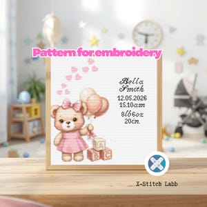 Könnte beinhalten: Kreuzstichmuster mit einem Teddybären, der Ballons und Blöcke hält, mit dem Namen "Bella Smith" und Geburtsdetails. Das Design umfasst rosa Herzen und den Text "Pattern for embroidery". Das Bild ist in einem Holzrahmen gerahmt.