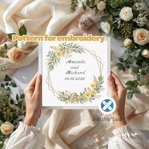 May include: A framed embroidery pattern featuring a floral wreath with yellow flowers and green leaves, surrounding the names "Amanda and Richard" and the date "06.06.2026". The text "Pattern for embroidery" is at the top.