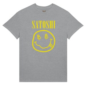 Peut inclure: T-shirt gris avec le mot "SATOSHI" en jaune au-dessus d'un smiley jaune avec des yeux en forme de symbole dollar et une langue tir&eacute;e. Le t-shirt est de style col rond.