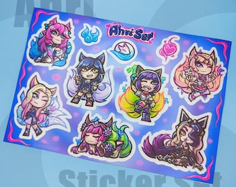 Könnte beinhalten: Eine Sticker-Tafel mit 8 bunten Comicfiguren aus dem Videospiel League of Legends. Die Figuren sind alle Variationen des Charakters Ahri, ein neunschwänziger Fuchsspirit. Die Sticker-Tafel trägt den Titel "Ahri Set" und hat einen rosa, blauen und violetten Hintergrund.