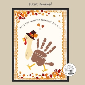 Può includere: Stampa artistica a tema Ringraziamento con un tacchino realizzato con un'impronta della mano. Il tacchino indossa un cappello da pellegrino ed è circondato da foglie autunnali. Il testo "THIS LITTLE TURKEY IS THANKFUL FOR YOU!" è visualizzato. L'immagine è incorniciata in nero.