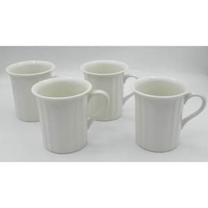 May include: Four white ceramic mugs with curved handles are arranged on a white surface. Each mug has a slightly flared rim and a delicate embossed floral design near the top. The mugs are evenly spaced and appear to be new.