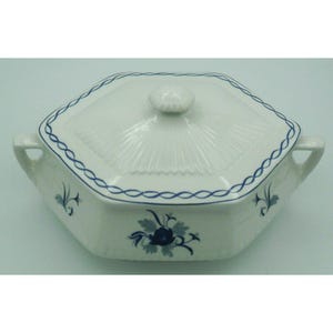 May include: White ceramic serving dish with a lid. The dish has a hexagonal shape with blue floral and vine designs. A blue chain-like pattern borders the rim. The lid has a small, round handle.