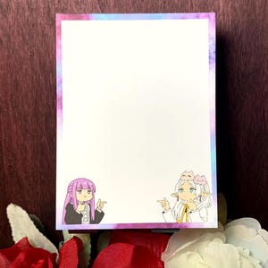 May include: A white notepad with a watercolor-style border in shades of purple and blue. The notepad features two cartoon characters pointing. One character has pink hair and the other has white hair.