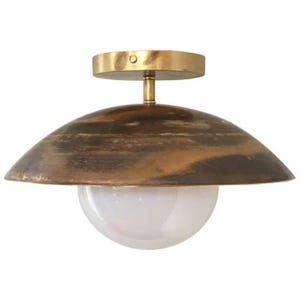 Puede incluir: Lámpara de techo con acabado en latón y pantalla abovedada de bronce envejecido. Cuenta con un difusor de vidrio blanco en forma de globo. El diseño es una mezcla de estilos vintage y modernos, adecuado para varios interiores.