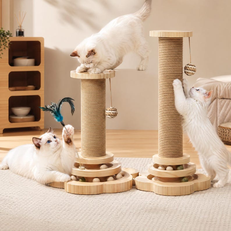 May include: Two light-colored wooden cat scratching posts with sisal rope-wrapped columns, flower-shaped bases with integrated ball tracks, hanging woven toy balls, and a detachable blue feather wand toy, featuring three white cats interacting.