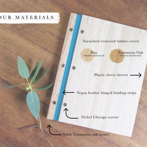 An A4 size timber folder rests on a wooden table. Graphics have been superimposed over the book, pointing to details in the construction of the book. Details include nickel screws, vegan leather binding and examples of pine and Tasmanian oak veneer.
