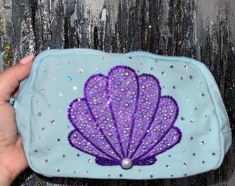 Bolso de sirena inspirado en Ariel: monedero morado brillante con forma de concha, ideal para el atuendo de los parques Disney.