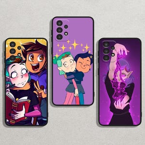 Op de afbeelding: Drie telefoonhoesjes met kleurrijke cartoon illustraties. Eén hoesje toont drie personages met een boek, een ander toont twee personages die elkaar omhelzen, en de laatste heeft een personage met paarse energie. De hoesjes zijn zwart en paars.