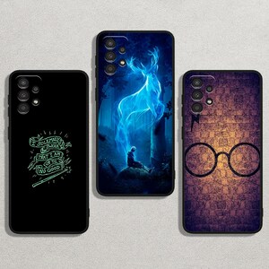 May include: Three black phone cases with unique designs. One case features a glowing green quote, another showcases a blue stag in a forest, and the third displays glasses and a lightning bolt on a brick background.