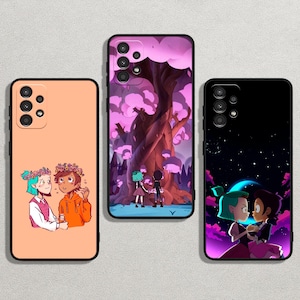 Op de afbeelding: Drie telefoonhoesjes met zwarte randen en kleurrijke illustraties. Eén hoesje toont twee personages met bloemenkransen, een ander toont een boom met twee figuren en de laatste toont twee personages onder een sterrenhemel. De hoesjes zijn in perzik, roze en zwart.