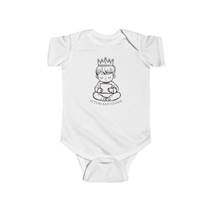Könnte beinhalten: Weißer Baby-Body mit einer Schwarz-Weiß-Illustration eines Kindes mit Krone und Tablet. Der Text "FUTURE RAID LEADER" ist darunter aufgedruckt. Der Body hat kurze Ärmel und einen Druckknopfverschluss.