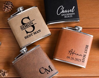 May include: Four personalized flasks in various colors: black, tan, brown, and orange. Each flask has a silver cap and is engraved with names, initials, and dates. A small funnel and a metal jigger are also visible.