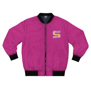 Könnte beinhalten: Eine rosafarbene Bomberjacke mit schwarzem Reißverschluss und schwarzen gerippten Bündchen und Bund. Die Jacke hat ein farbenfrohes "S"-Logo auf der linken Brust.