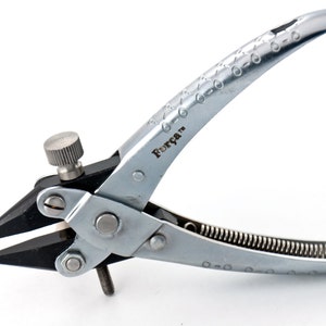 May include: Silver-toned pliers with a black handle and a spring. The pliers have a knob on the top and the text "Força™" is printed on the side.