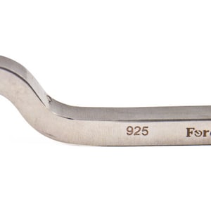 May include: A silver metal jewelry making tool with a curved handle and a flat, rectangular base. The tool is marked with the number "925" and the word "Força™".