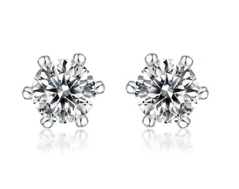 May include: A pair of sparkling diamond stud earrings. Each earring features a round, brilliant-cut diamond set in a six-prong silver or white gold setting. The diamonds reflect light, creating a dazzling display against a white background.