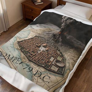 Può includere: Una coperta con una mappa dettagliata di Pompei, Italia, con una raffigurazione del Vesuvio in eruzione. La coperta ha un'estetica vintage con il testo "Pompei 79 D.C." stampato sopra. La mappa mostra la planimetria della città e i dintorni.
