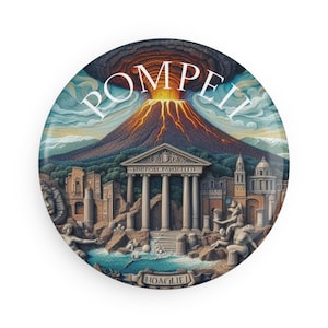 Può includere: Un bottone rotondo con un'illustrazione colorata dell'antica città romana di Pompei, con un vulcano in eruzione sullo sfondo, un tempio in primo piano e il testo "POMPEII" in lettere bianche.