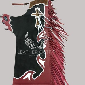 Peut inclure: Chaps en cuir noir et bordeaux avec des détails blancs et des franges. Comprend une croix et un motif d'ailes, avec le texte "LEATHER OUTFIT BY ABUL". Les chaps ont une ceinture décorative en cuir et sont conçus pour l'équitation.