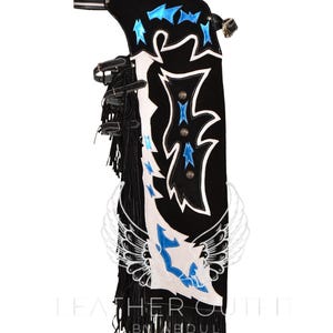 May include: Black leather chaps with white and blue embroidery. The chaps feature a fringe detail and a wing design. The text "Leather Outfit by Abdul" is visible at the bottom of the image.