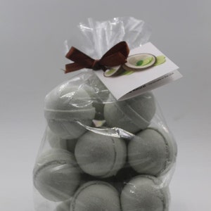 May include: A clear cellophane bag filled with several light green bath bombs. The bag is tied with a brown ribbon and a small tag with a lime illustration. The bath bombs have a seam around the middle.
