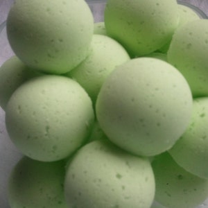 May include: A bowl filled with round, light green bath bombs. The bath bombs have a textured surface.