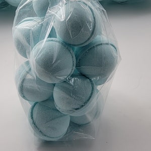 May include: A clear plastic bag filled with light blue bath bombs. The bath bombs are round and have a smooth surface.