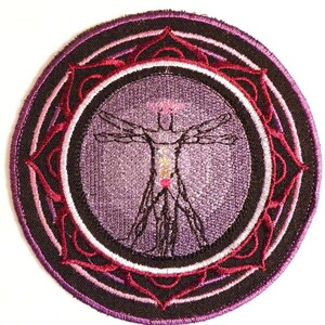 May include: Embroidered patch with a purple, pink, and red mandala design. The center of the mandala features a stylized human figure with outstretched arms.