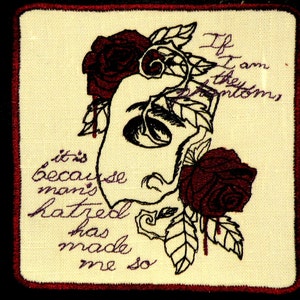 May include: Embroidered patch with a black and white illustration of a face with roses and leaves. The text "If I am the symptoms it's because man's hatred has made me so" is embroidered in purple.