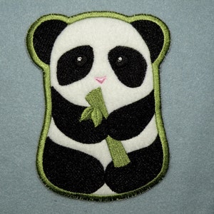May include: A black and white panda bear with green bamboo in its paws. The panda is sitting on a light blue background.