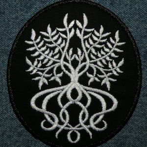 May include: A white embroidered tree with intricate roots on a black circular patch.