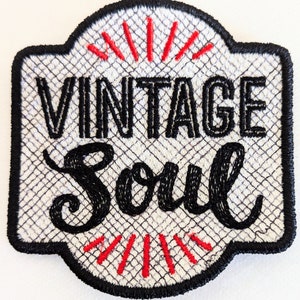 May include: White embroidered patch with black text that reads "Vintage Soul". The text is in a stylized font. The patch has a black border and red stitching around the edges.
