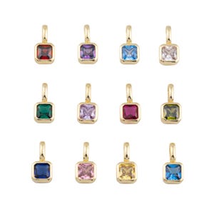 K&ouml;nnte beinhalten: Eine Sammlung von zw&ouml;lf goldfarbenen Anh&auml;ngern, jeweils mit einem quadratisch geschliffenen Edelstein in einer anderen Farbe. Die Edelsteine umfassen Rot, Lila, Blau, Klar, Gr&uuml;n, Rosa und Gelb. Jeder Anh&auml;nger hat oben eine kleine Schlaufe.