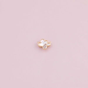 May include: A gold-coloured cloud charm featuring a white mother-of-pearl inlay and a clear, teardrop-shaped crystal. The charm has small loops for attaching to jewellery. The background is a soft pink.